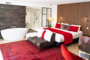 圣拉斐尔Le Confidentiel Hôtel & SPA的一间卧室设有一张大床和一个浴缸