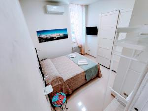 莫诺波利Casetta Mia的一间白色的小卧室,配有一张床和梯子