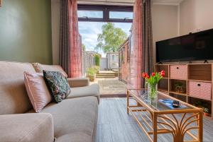 ParksideClose to A46 City Centre Sleeps 6, 5 Beds Ensuite FREE Wi-Fi Queens House Inspire Homes的带沙发、电视和桌子的客厅