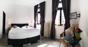 亚琛克兰克斯埃姆巴豪夫酒店的一间卧室设有一张大床和两个窗户。