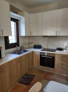 费索斯Marilia Home的厨房配有木制橱柜、水槽和窗户。