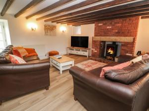 彭赞斯Trevedran Cottage的客厅设有两张沙发和一个壁炉