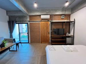 曼谷Loft 202 Hotel的客房设有床、电视和沙发。