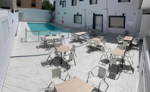 奥萨德蒙铁尔Hostal La Paz的一个带桌椅的庭院和一个游泳池