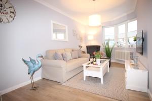 青斯特KranichSuite - Zingst的客厅配有白色的沙发和桌子