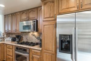 拉昆塔Oak Tree Manor Permit# 259,056的厨房配有木制橱柜和不锈钢用具