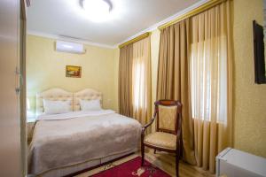 库塔伊西HOTEL VLADi的配有一张床和一把椅子的酒店客房