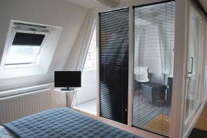 格罗宁根Loft 6 kingsize apartment 2-4persons with great kitchen的卧室设有窗户、一张床和一台电视