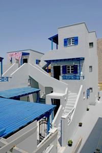 佩里萨Lunar Santorini Hotel的白色的大建筑,设有蓝色的窗户和楼梯