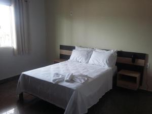 帕劳阿佩巴斯HOTEL QUALITY的一间卧室配有带白色床单和白色枕头的床。