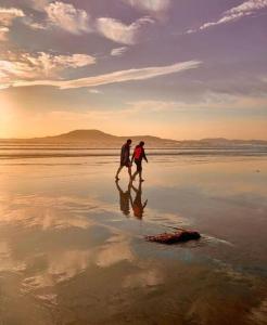 TawnyinahThe Nook的两人在日落时分在海滩上散步