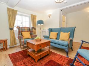 多切斯特Bell Cottage的客厅配有两把椅子和一张桌子