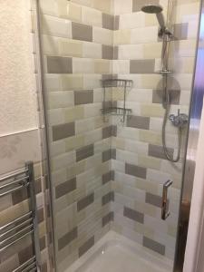 兰迪德诺肯莫尔旅馆的浴室设有灰色和灰色瓷砖淋浴。