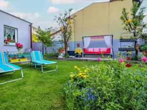 格洛格尼茨Apartment Gloggnitz by Interhome的庭院里设有两把椅子和长凳,鲜花盛开