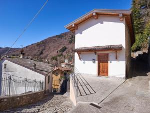 Casasco IntelviHoliday Home Casa del Sole by Interhome的白色的建筑,设有木门和栅栏