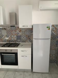 蒙泰迪普罗奇达Residence R&B Tyrrhenum的白色的厨房配有炉灶和冰箱。