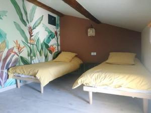 蒙特La ferme des Escampades的卧室配有两张床,墙上挂有壁画
