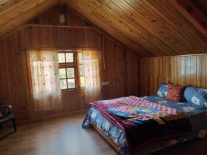 甘托克Sherpa Villa的木制客房内的一间卧室,配有一张床