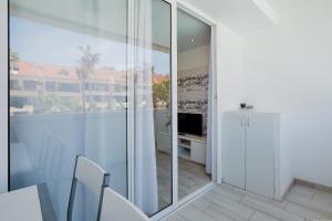 阿罗纳Beautiful apartment Playa Honda in the heart of Las Americas的白色客房,设有滑动玻璃门