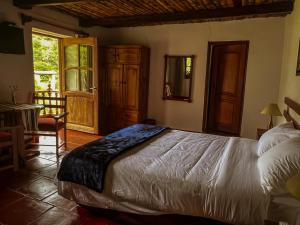 查查波亚斯Hotel Fundo Achamaqui的一间卧室配有一张床、一张桌子和一个窗户。