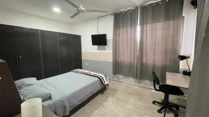 切图马尔Departamento Orellana 11的一间卧室配有一张床、一张书桌和一台电视