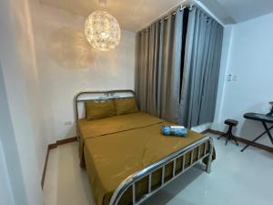 卢塞纳Sto. Niño Residences Standard Room的一间带一张床和吊灯的小卧室