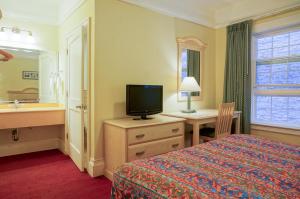 旧金山格兰特酒店的酒店客房配有一张床和一张书桌及一台电视