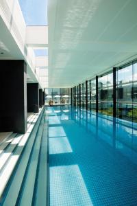 墨尔本皇冠江滨酒店的一座大型游泳池,位于一座带玻璃窗的建筑内