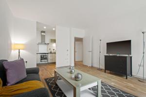 伦敦South Quay Apartments Canary Wharf的带沙发和电视的客厅