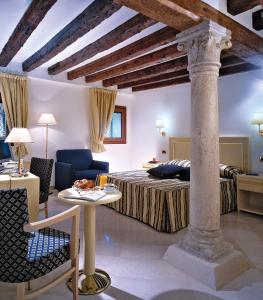威尼斯威尼斯朱代卡酒店的酒店客房带一张床、一张桌子和椅子