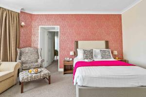 埃克斯茅斯皇家灯塔酒店的一间卧室配有一张带粉红色墙壁的大床
