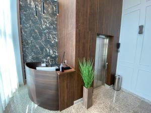 塔瓜汀加Miami Hotel by H Hotéis - Business的浴室设有木浴缸,内有植物