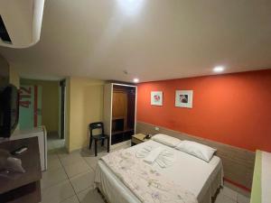 累西腓Rede Andrade Plaza Recife的一间卧室配有一张橙色墙壁的床
