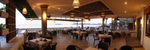 曼萨尼约马贝拉酒店的一间带桌椅的海景餐厅