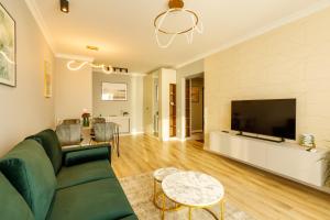 马马亚Lago Apartment Mamaia Butoaie的客厅配有绿色沙发和平面电视