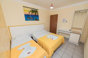 纳塔尔Pousada Terra do Sol Natal的酒店客房,设有两张床和镜子