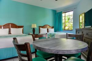尼格瑞尔可可棕榈酒店的一间设有两张床和一张桌子及椅子的房间