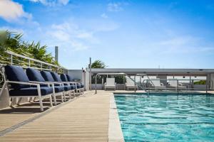 迈阿密海滩Bay Harbor One Vacation的大楼内带椅子的甲板和游泳池