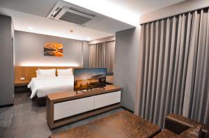 Ban Si ThanThe S Block Condotel的酒店客房,配有床和桌子上的电视