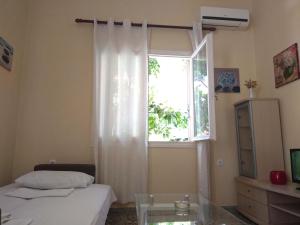 雷夫卡达镇OLEA Apartments的一间卧室设有窗户、一张床和一张玻璃桌
