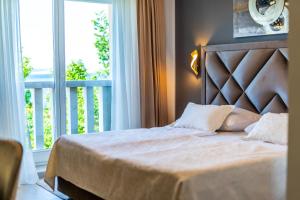 茨里克韦尼察Heritage Hotel Stypia的一间卧室设有一张大床和一个阳台