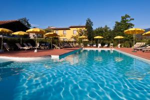 萨尔扎纳安蒂科卡萨莱酒店的度假村内带椅子和遮阳伞的游泳池