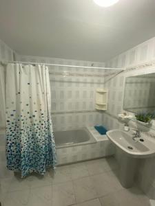托罗克斯科斯塔Apartamento Arena y Sal的带浴缸、水槽和淋浴帘的浴室