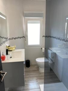 苏安塞斯NUEVO!!! PISO CENTRICO EN SUANCES -Sol Luxury-的一间带两个盥洗盆、卫生间和窗户的浴室