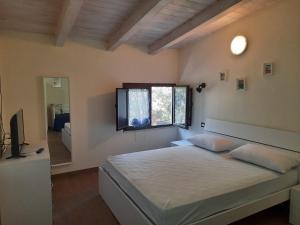 卡梅罗塔码头Villetta del Poggio的一间卧室设有一张大床和一个窗户。