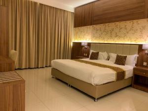 塔伊夫Kayan Al Taif Hotel的一间位于酒店客房内的带大床的卧室
