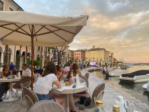 萨罗Violetta Maison, elegante e romantica a Salo’的一群人坐在运河附近的桌子旁