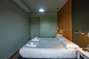 里斯本Luxury apartment near Fonte Luminosa的一间设有三张床的房间,配有白色毛巾
