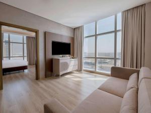 迪拜Movenpick Jumeirah Village Triangle的带沙发和电视的客厅