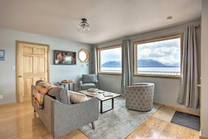 Remote Island Escape with Breathtaking Views的客厅配有沙发、两把椅子和窗户